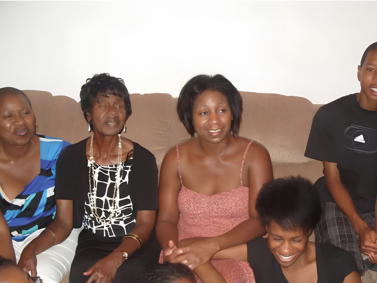 Mama Mercy surrounded by family in a living room